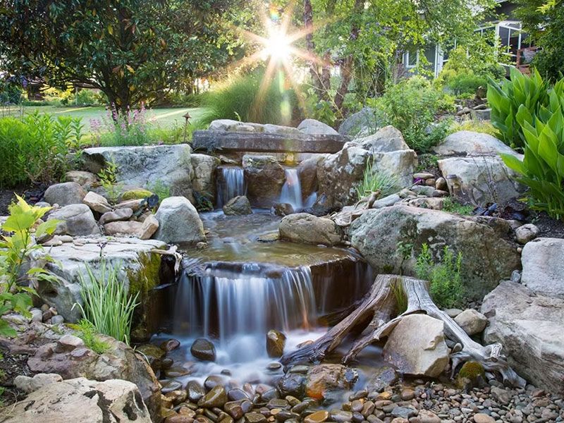 Pondless waterfall with low sun shining through trees behind