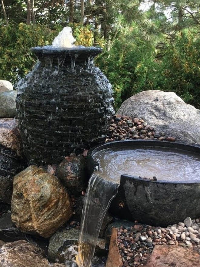 Slate urn and bowl fountain among boulders