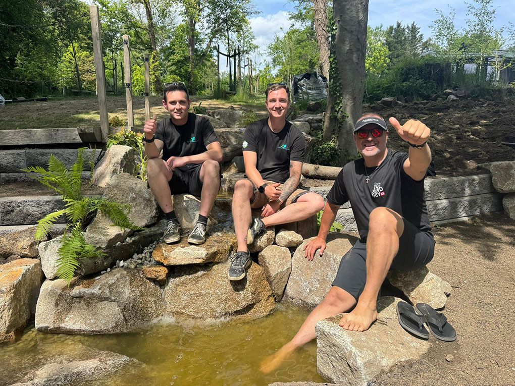 The Aquatic Landscapes team sitting on the rockwork of a stream they are building